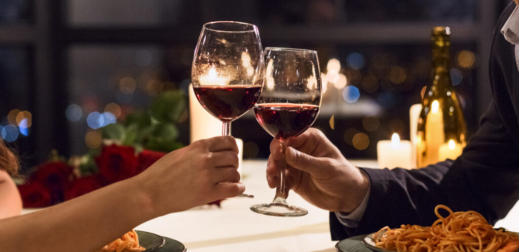 Hands Holding Glasses Of Wine On Restaurant